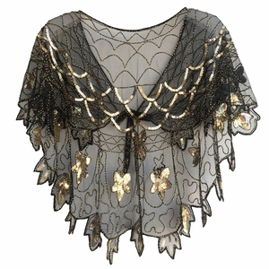 Détail macro d'un châle en maille noire avec paillettes dorées et motifs papillons