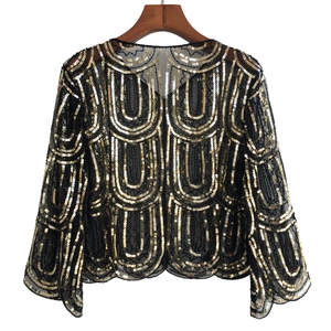Detail of evening mesh shawl with golden geometric sequins and sheer black fabric