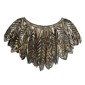 Detail of 1920s Gatsby vintage black mesh shawl with gold sequins and Art Deco patterns