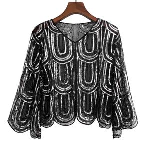 Detail of black mesh shawl featuring silver sequins in geometric U-shaped patterns