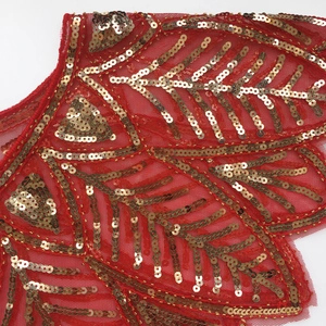 Detail of red mesh shawl featuring gold sequins in retro leaf and feather patterns