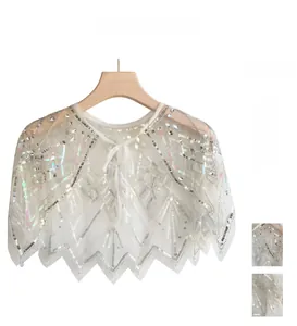 Detail of white mesh capelet with silver sequins in geometric patterns and wavy edges