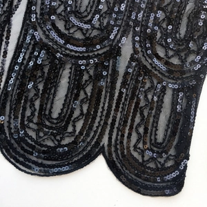 Detail of 1920s mesh shawl featuring black sequins and a scalloped edge finish