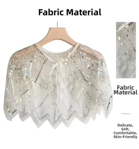 Detail of white lace capelet with silver sequins and beads on soft mesh fabric