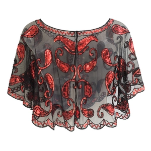 Close-up of black mesh capelet featuring red paisley sequins and scalloped hem