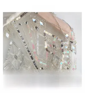Macro detail of white tulle shawl with sparkling silver sequins and beadwork embroidery