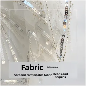 Close-up of white lace fabric with handmade silver beaded sequins and craft details