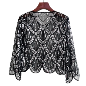 Detail of black mesh shawl with silver sequins in scalloped pattern for evening dresses