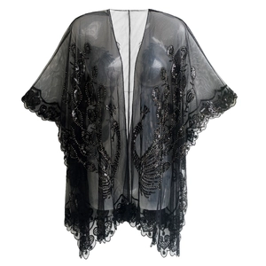 Détail du châle en tulle noir avec paillettes à motif plume de paon et dentelle