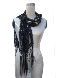 Detail of black mesh shawl with gold and silver sequins and elegant long fringe trim