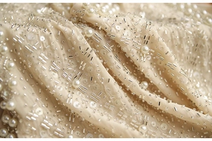 Macro d'une broderie de luxe avec perles argentées et sequins sur mousseline champagne