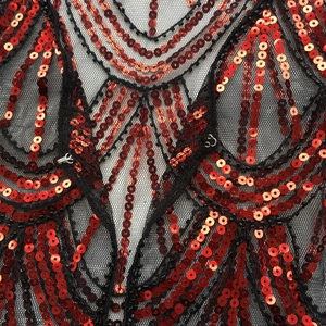 Detailed macro view of black mesh fabric with red sequins and metallic front hook closure