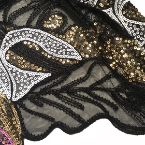 Detail of black mesh lace with intricate gold sequins and vintage scroll embroidery