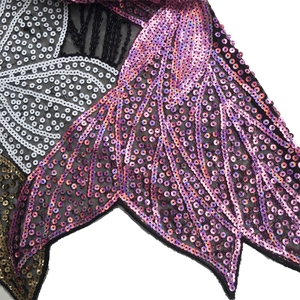 Detail of heavy beadwork and iridescent sequins on black mesh lace fabric for women top