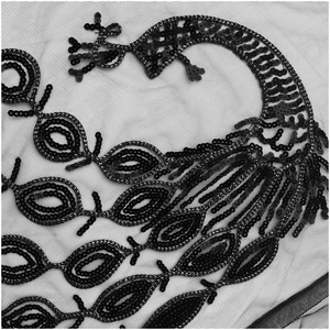 Vue détaillée de la broderie complexe de paillettes noires sur le châle de soirée