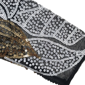 Detailed macro view of intricate gold and silver sequins on black mesh fabric