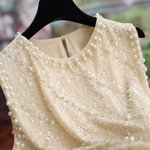 Haut chic sans manches en mousseline avec broderies de perles et de sequins à l'encolure