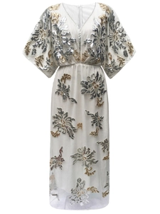 Detailed close-up of gold and silver sequins on elegant white V-neck evening dress