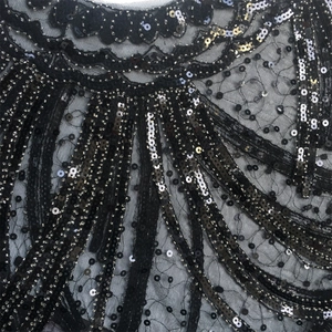 Macro detail of 1920s vintage evening shawl with black and gold sequins on mesh