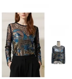 Dettaglio del top in mesh nero trasparente con paillettes blu e oro a onde eleganti