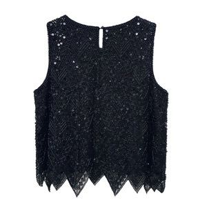 Close-up of heavy beadwork and sequins on black vest with irregular jagged hem