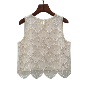Détail des broderies de perles et paillettes sur le gilet sans manches en tulle