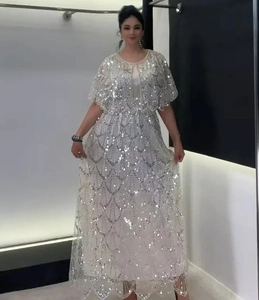 Dettaglio dei ricami di paillettes bianche e del design mantella elegante sull'abito da sera