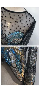 Dettaglio del top in mesh nero con paillettes colorate e decorazione di perline sulle spalle