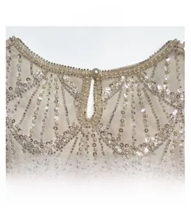 Détail d'un haut en mesh avec perles, paillettes et décolleté goutte d'eau