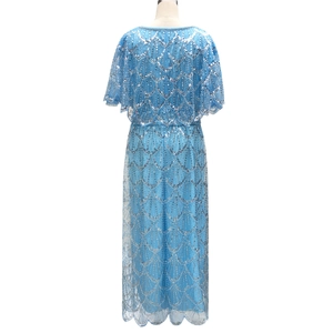 Detail of light blue sequin dress featuring silver wave patterns and a cape-style design