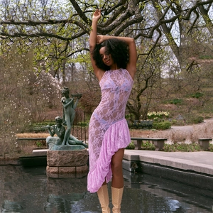 Detail of mauve lace sheer dress with halter neck and asymmetric ruffled hemline