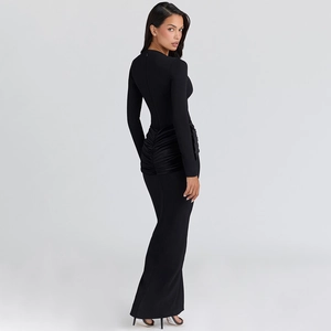 Detail of elegant black ruched maxi dress showing side silhouette and pleated fabric texture