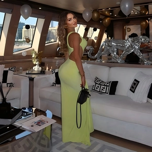 Détail d'une robe longue dos nu vert citron avec découpes sur un yacht de luxe