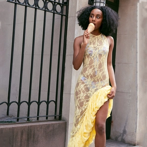 Lace detail of yellow sheer floral crochet dress with halter neck and mermaid hemline