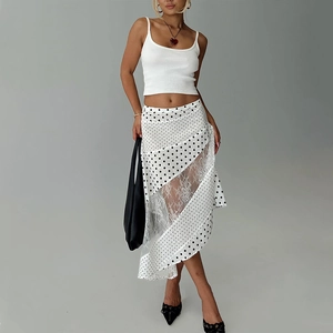 Close-up of white polka dot skirt with sheer lace splicing and asymmetrical hem detail