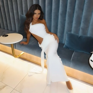 Détail d'une robe longue blanche à une épaule avec découpe élégante et drapé fluide