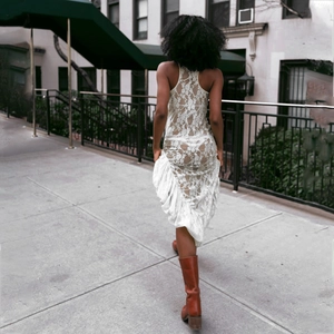 Close-up of intricate white lace pattern and sheer open back detail on a summer dress