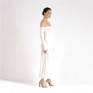 Vue latérale d'une robe en maille blanche à épaules dénudées avec détails drapés