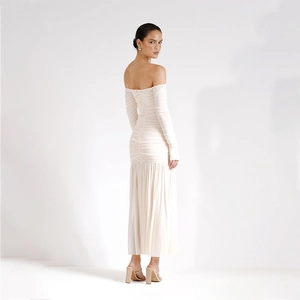 Détail de la robe longue drapée à manches longues en blanc cassé avec ourlet plissé