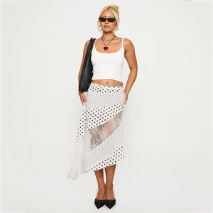 Detail of asymmetrical polka dot skirt featuring sheer lace patchwork and irregular hem