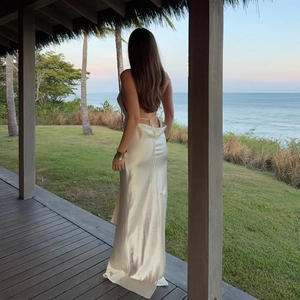 Detail of elegant backless halter neck champagne satin maxi dress with tie closure