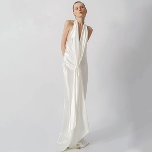 Detail of white satin halter neck dress showing the V-neck and knotted waist drape