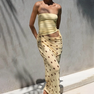Détail d'un haut bustier jaune et d'une jupe longue à pois pour un look d'été