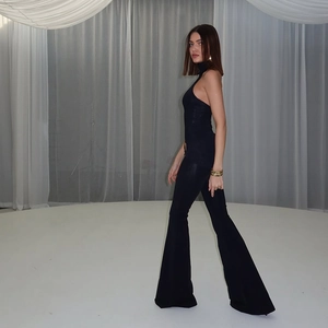 Detailansicht des schwarzen Neckholder-Jumpsuits mit weitem Bein und glänzendem Stoff