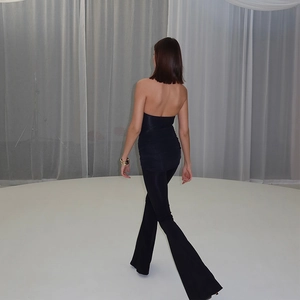Makroaufnahme von schwarzem rückenfreiem Halter-Jumpsuit mit Schlaghose und hoher Taille