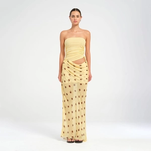 Détail d'un ensemble jaune à pois avec jupe en maille et haut bandeau ajusté