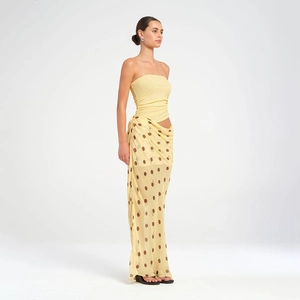 Détail d'un haut bustier jaune clair et d'une jupe longue à pois pour la mode féminine