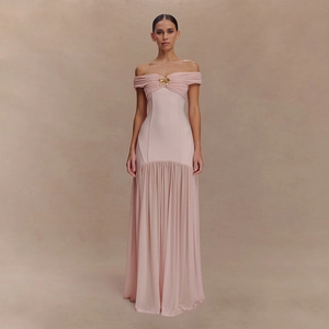 Détail de la robe rose à épaules dénudées avec corsage plissé et broche fleurie dorée