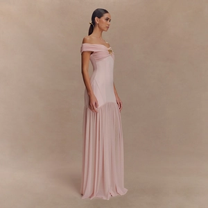 Détail de la robe en maille rose pâle à épaules dénudées avec étoile dorée et jupe en tulle