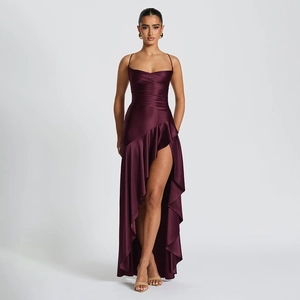 Détail d'une robe de soirée en satin avec fente haute, volants et tissu rouge vin chic